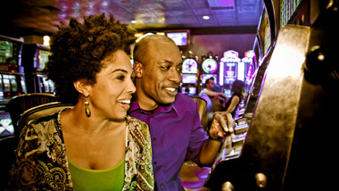 two guests playing a slot machine